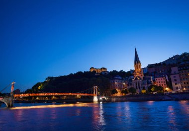 Vieux Lyon Güzel cityscape Saone nehir ve alacakaranlık, Fransa sırasında St. George Kilisesi arasında ışıklı yaya köprüsü ile