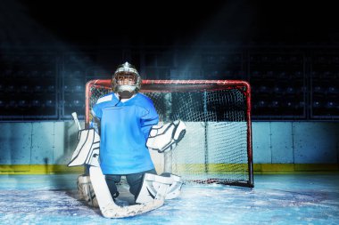 Onun net hokey oyun sırasında koruma sırasında genç goaltender ayakta diz çökmüş pozisyonda portresi