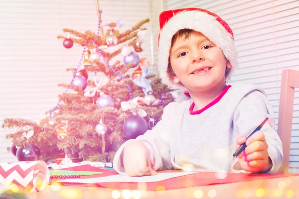 Garoto Sorridente Chapéu Papai Noel Escrevendo Uma Carta Natal Olhando — Fotografia de Stock