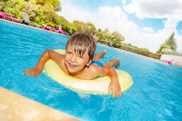 Retrato Niño Feliz Flotando Tubo Baño Amarillo Piscina Mirando Cámara — Foto de Stock