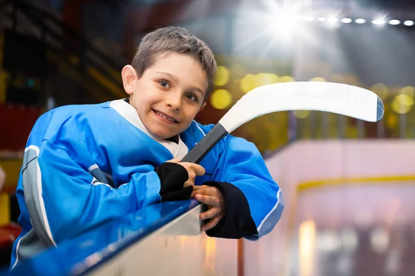 スケート場の掲示板で幸せな少年 アイス ホッケー プレーヤーの肖像画が傾いています — ストック写真