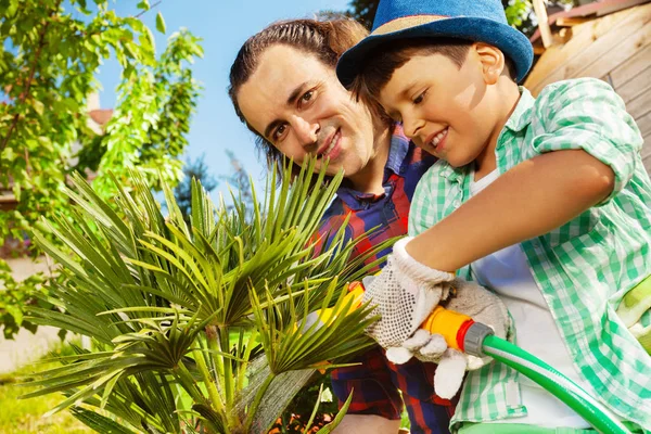 Close Portrait Young Father His Son Watering Palm Three Using — Stock Photo, Image