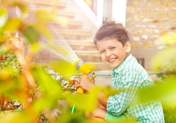 快乐的小园丁肖像 七岁的男孩 在后院浇水玫瑰丛 — 图库照片