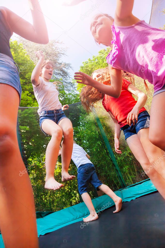 Portrait of happy children enjoying jumping on the trampoline during summer vacation