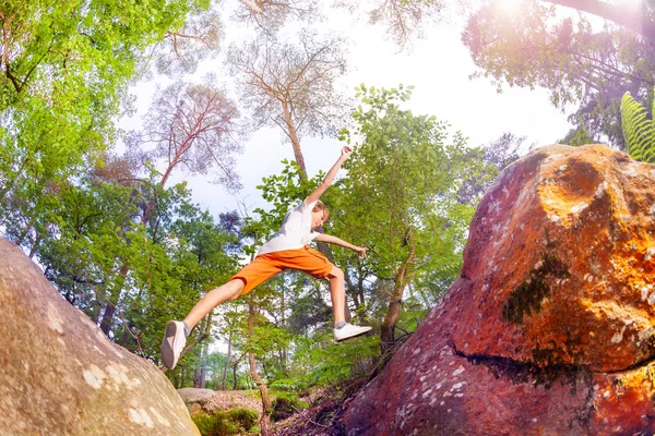 Мальчик Воздухе Прыгает Одной Скалы Другую Балансируя Руками Лесу — стоковое фото