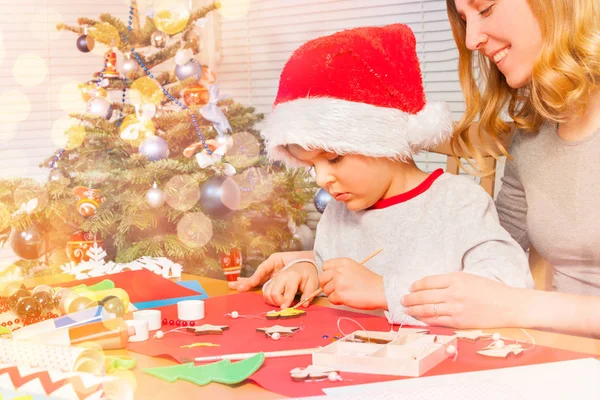 Niño Sombrero Santa Decorando Adornos Navidad Madera Con Mamá —  Fotos de Stock