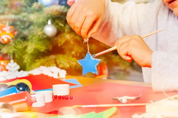 Primer Plano Mano Del Niño Sosteniendo Adorno Navidad Madera Pintándolo —  Fotos de Stock