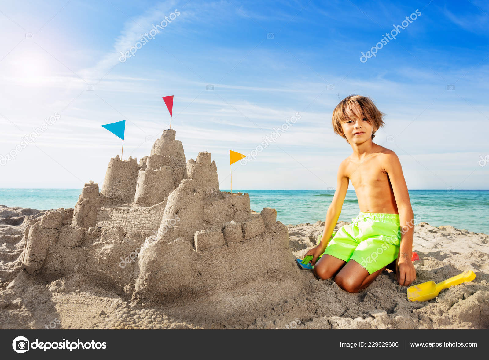 garçons heureux faisant un château de sable sur la plage