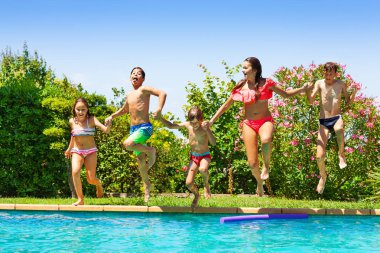 Beş yaş-çeşitli baylar bayanlar, açık havuz içine atlama sırasında elele portresi