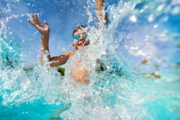 幸せな男の子を再生し スイミング プールで水しぶきの肖像画 — ストック写真