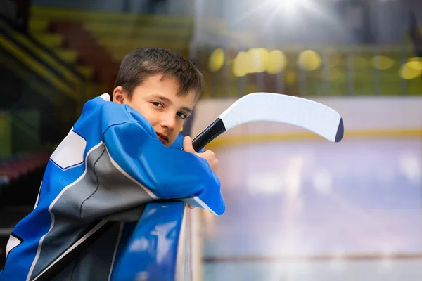 代の少年 プロのアイス ホッケー選手 スケート リンク ボードの後ろに立っての側面の肖像画 — ストック写真