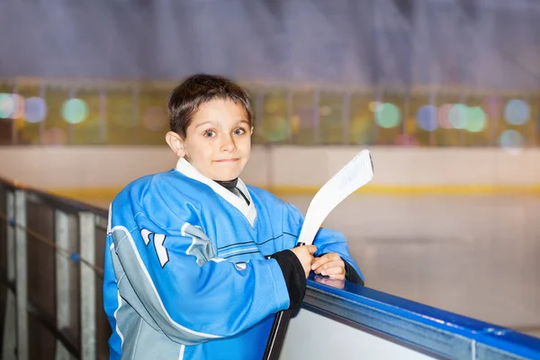 アイス ホッケー プレーヤー ボードの後ろの棒で立っていると ゲームの入力を待っている幸せな少年の肖像画 — ストック写真