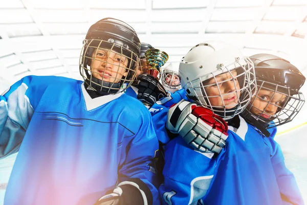 Close-up portrait of children's ice hockey team celebrating victory with the trophy in junior league