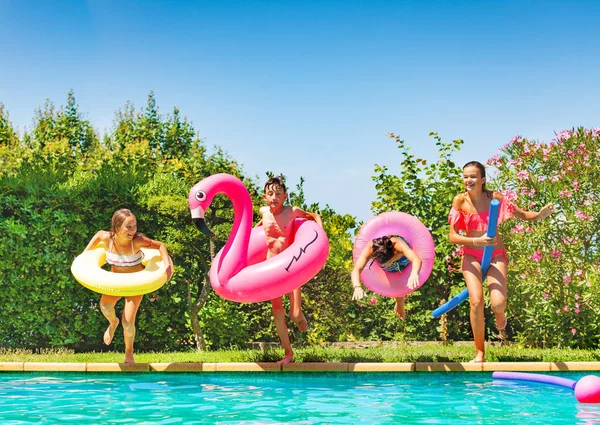 Grupo Cuatro Amigos Felices Niños Niñas Diversas Edades Anillos Natación —  Fotos de Stock