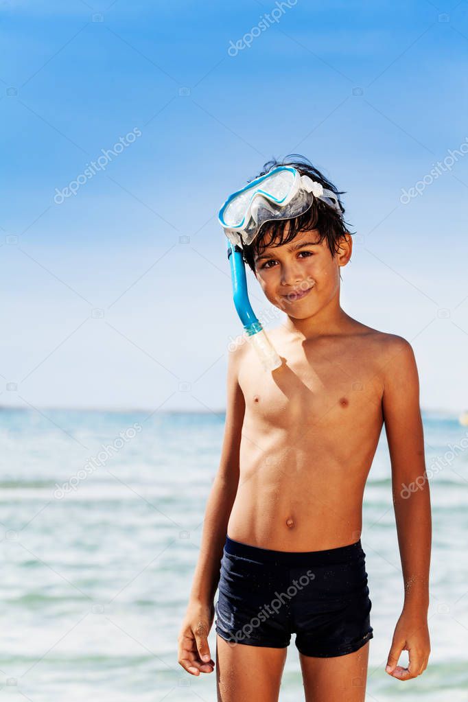Close-up portrait of preteen boy in swimwear and scuba mask spending summer vacation at the seaside