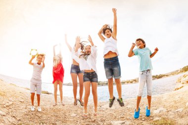 Yaş-çeşitli kızlar ve Erkekler eğleniyor, neşeli arkadaşları, portre yaz aylarında kumsalda atlama