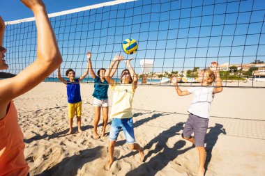 Genç baylar bayanlar, plaj voleybol oynarken, yaz aylarında deniz kenarında harcama mutlu arkadaşlar portresi