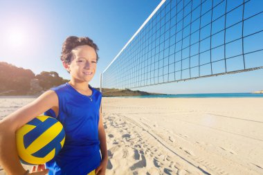 Plaj voleybol oyun için hazır Başlarken topu ile net yanında duran genç çocuk portresi