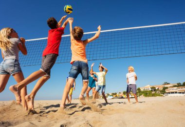 İki genç erkek birlikte net üzerinden topu spike için atlama, plaj voleybol oyuncular, arkadan görünüş