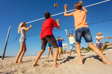Sahilde voleybol yarışmaya yaz sırasında topa vuruyor genç erkek arkadan görünüm