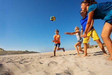 Mutlu genç baylar bayanlar plaj voleybolu oynarken yaz tatili