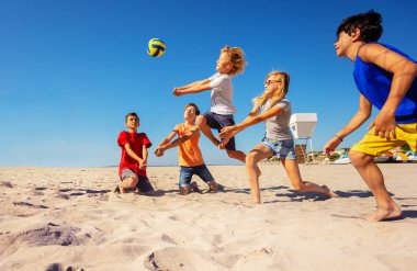 Genç baylar bayanlar plaj voleybolu sırasında geçmek bir şişlik oyun yapma portresi