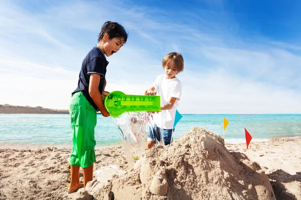 Portrait Two Boys Pouring Water Sand Mold Building Sandcastle Beach — Stock Photo, Image