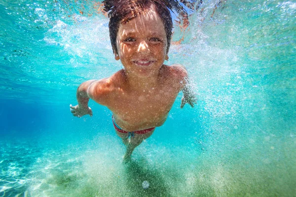 クリアブルーの海で水中を泳ぐことを学ぶに喜んでいる子供の少年のクローズ アップの肖像画 — ストック写真