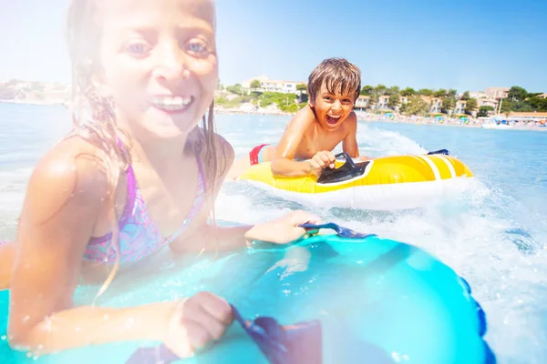 幸せな男の子と女の子にエアコンのマットレス 波に乗って海辺で休暇を過ごす — ストック写真