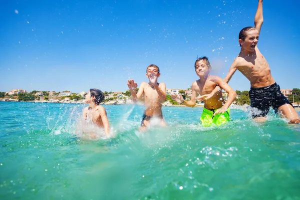 Porträtt Fyra Tonårspojkar Spelar Och Stänkande Vatten Havet — Stockfoto