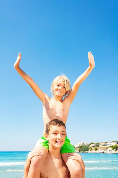 Portrait Teenage Boy Carrying Friend His Shoulders Beach Stock Image