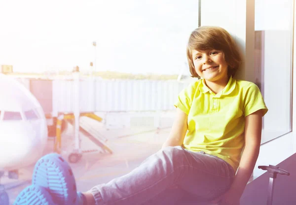 Portret Szczęśliwy Chłopiec Siedzący Obok Okna Patrząc Płaszczyźnie Podczas Oczekiwania — Zdjęcie stockowe