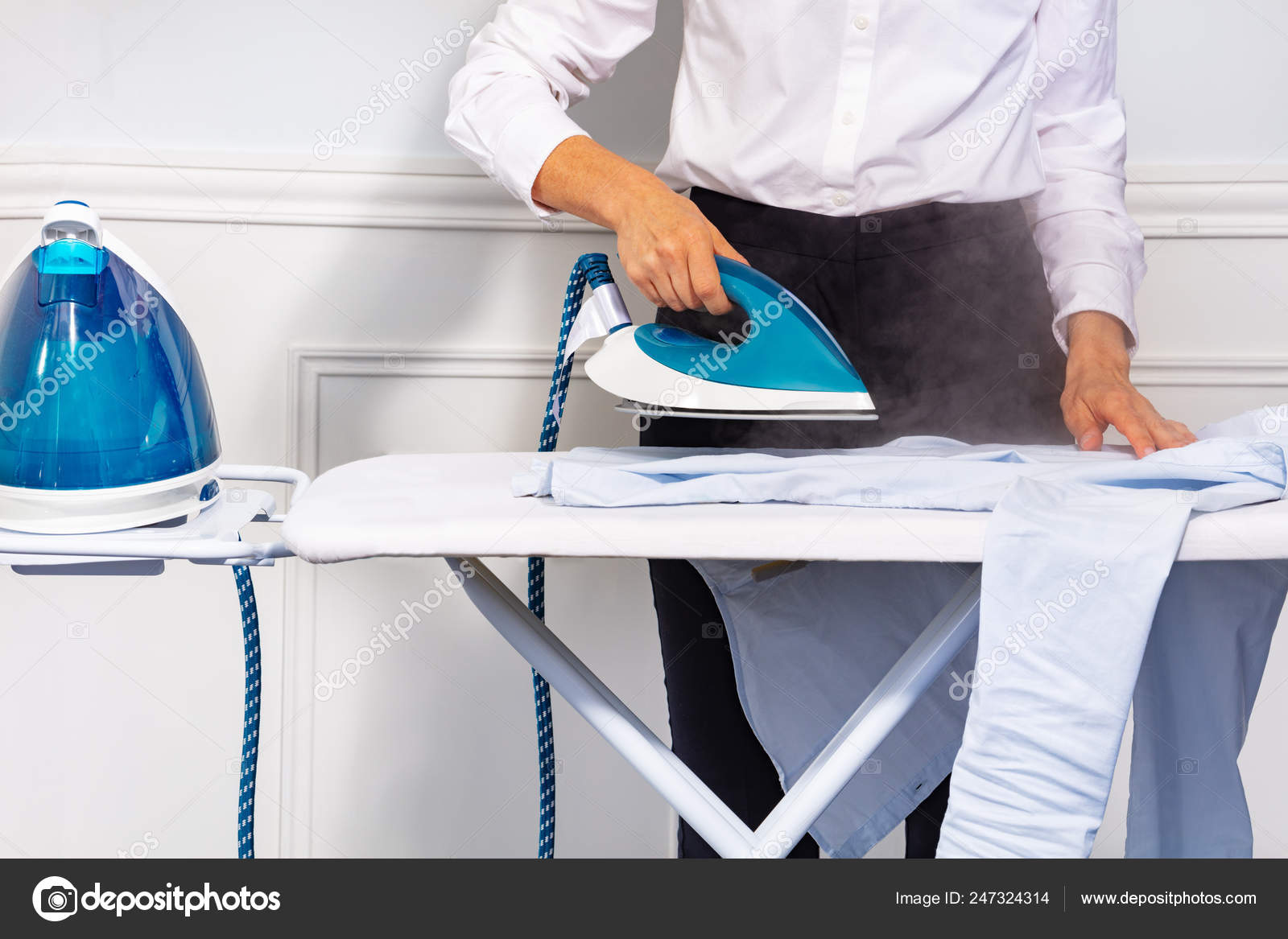 Close-up Of Woman's Hand Ironing Cloth On Ironing Board Stock