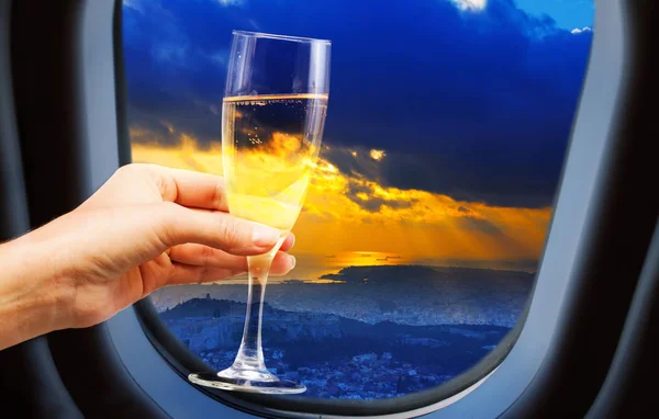 Vista de la ciudad desde la ventana del avión con copa de champán — Foto de Stock