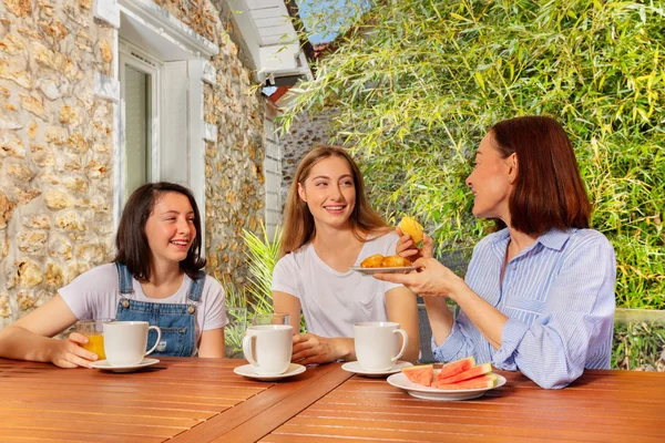 Mother having breakfast with daughters on terrace — Stock Photo, Image