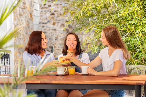 Mom and daughters having breakfast on the terrace — Stock Photo, Image