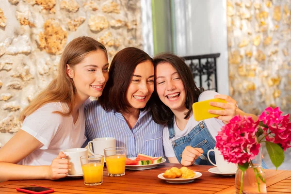 Mother and daughter taking selfie during breakfast — Stock Photo, Image