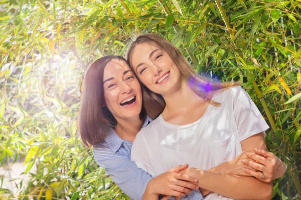 Happy mother hugging adult daughter from the back — Stock Photo, Image