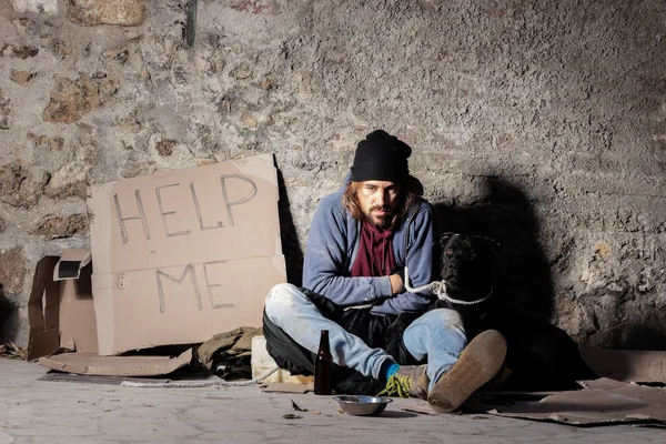 Homeless man sitting on the street with a dog — Stock Photo, Image