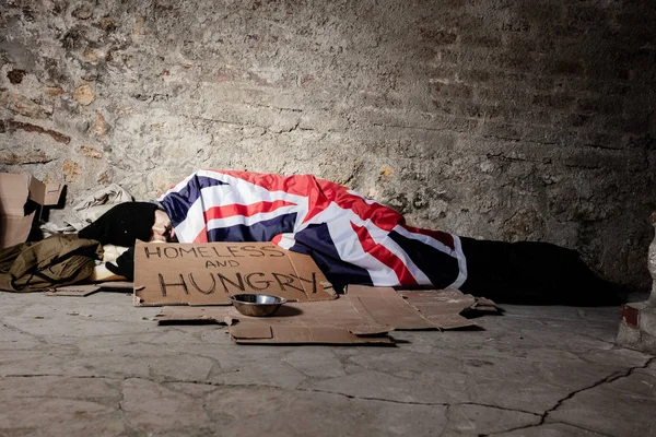 Homme dormant dans la rue sous drapeau britannique — Photo
