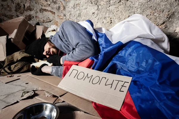 Homme couvert du drapeau russe dormant dans la rue — Photo