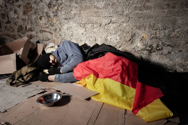 ドイツの旗の下で路上で寝ている男 — ストック写真