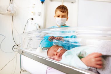 Küçük prematüre doğan bebek çocuk ve erkek kardeşi onu hastanede ziyaret