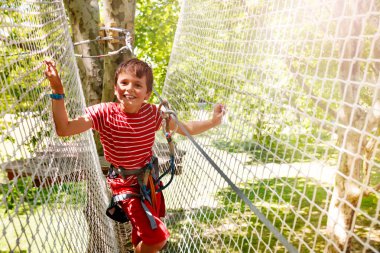 Bir ip macera parkı kablo boyunca yürüyen net küçük çocuk