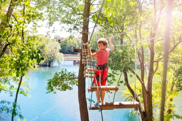 Malý Chlapec Chodí Vysoko Provazový Most Mezi Stromy Držící Kabely — Stock fotografie