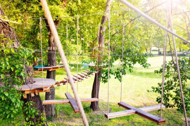 Çocuklar halat ormanda asılı ağaçlar üzerinde park ekipmanları yürüyüş