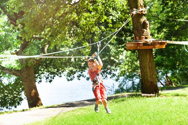 Fiú Csúszik Könnyű Alacsony Zip Sor Gyerekeknek Kalandpark Felett Gyepen — Stock Fotó