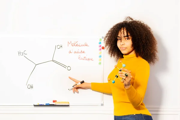 Młoda Afrykańska Dziewczyna Trzyma Molekułę Wskazująca Kwas Mlekowy Narysowany Białym — Zdjęcie stockowe