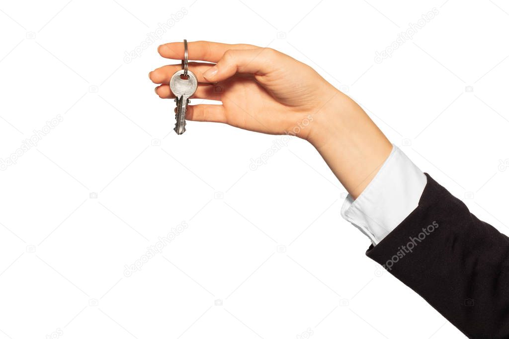 Woman's hand holding metal door keys on the ring, isolated on white