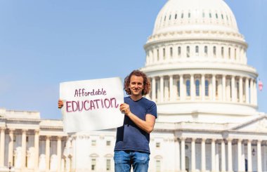 Washington'da ABD başkenti önünde adam protesto suyla uygun fiyatlı eğitim isteyen tabela